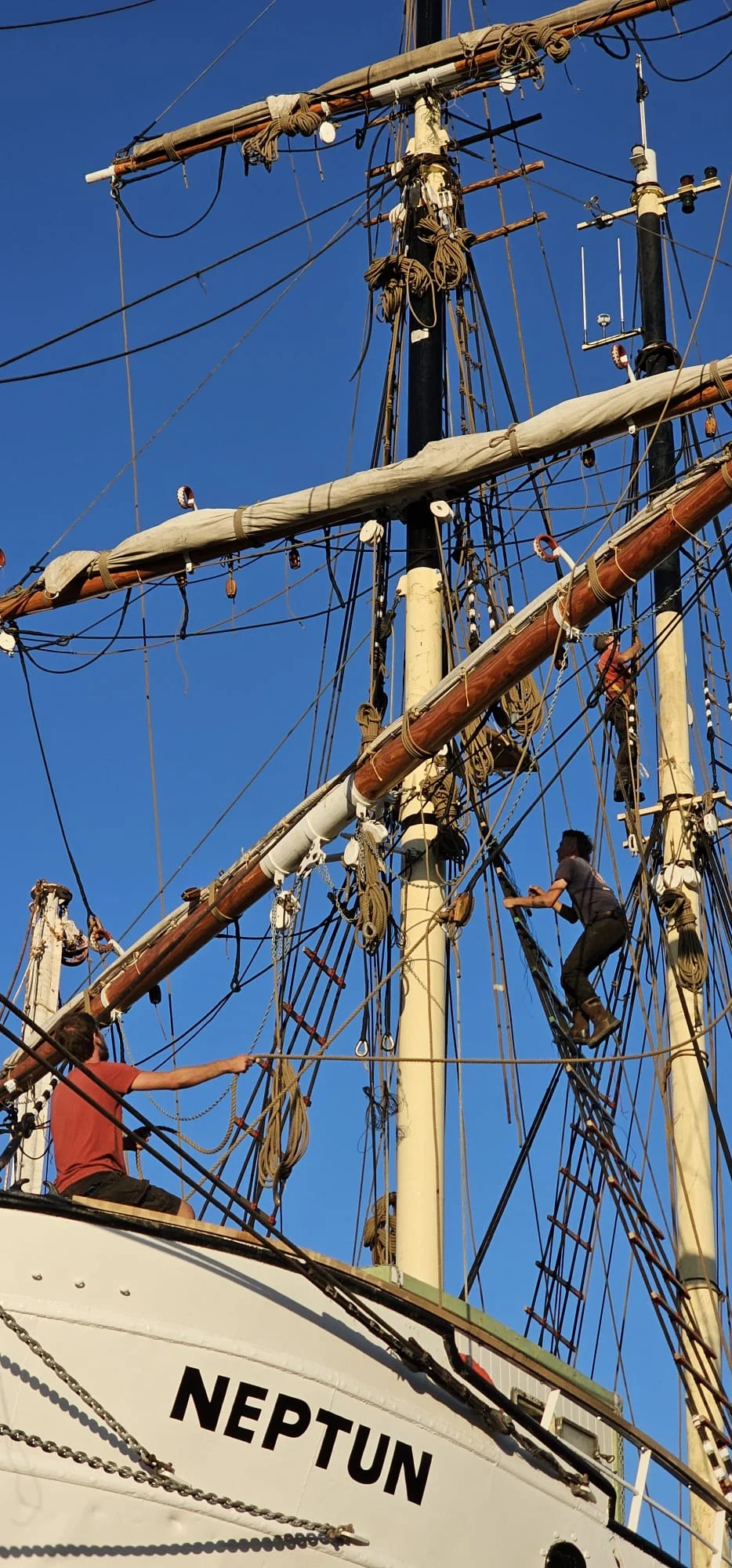 Crew at the helm of Brigantine NEPTUN mid-ocean