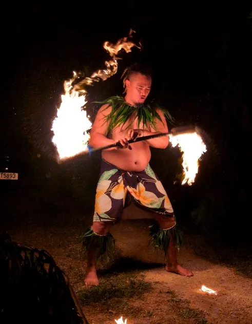 Latu performing a dramatic fire dance at the Tongan family feast