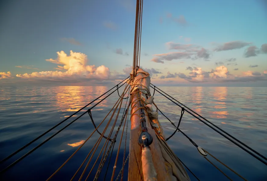 Mirror-flat doldrum sea reflecting the sky like NEPTUN is sailing among the clouds