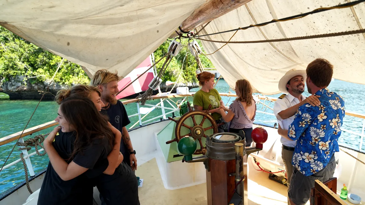 Crew exchanging goodbye hugs at the sign-off ceremony in Palau after eleven months at sea