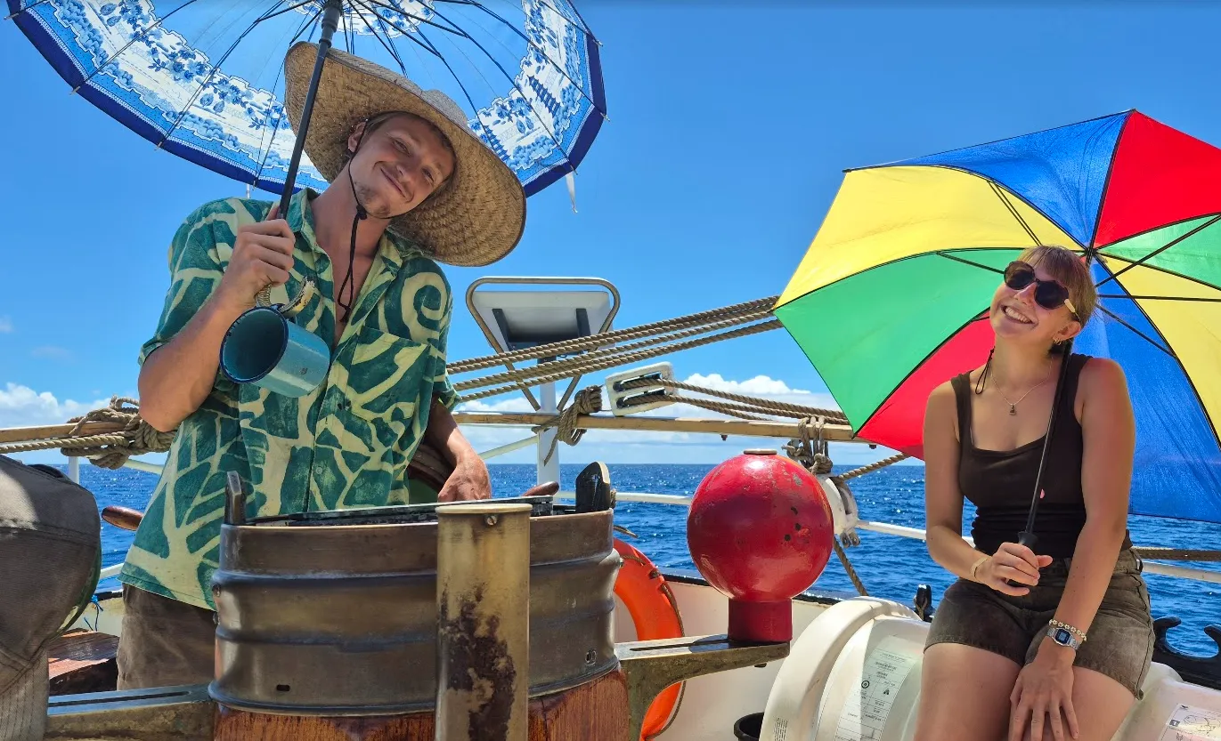 Helmsmen on NEPTUN sheltering from the equatorial sun with hats and umbrellas