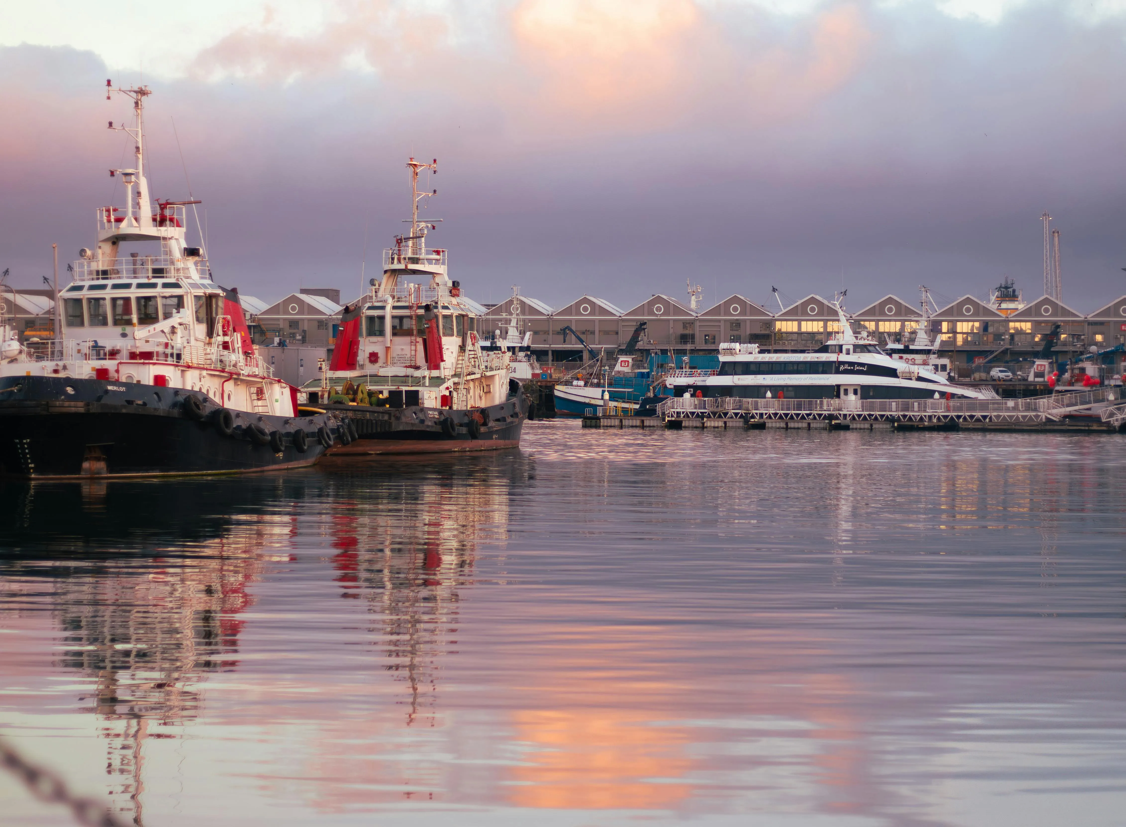 Cape Town waterfront at dusk, the 2026 Christmas layover, with the ship quiet and the crew ashore.