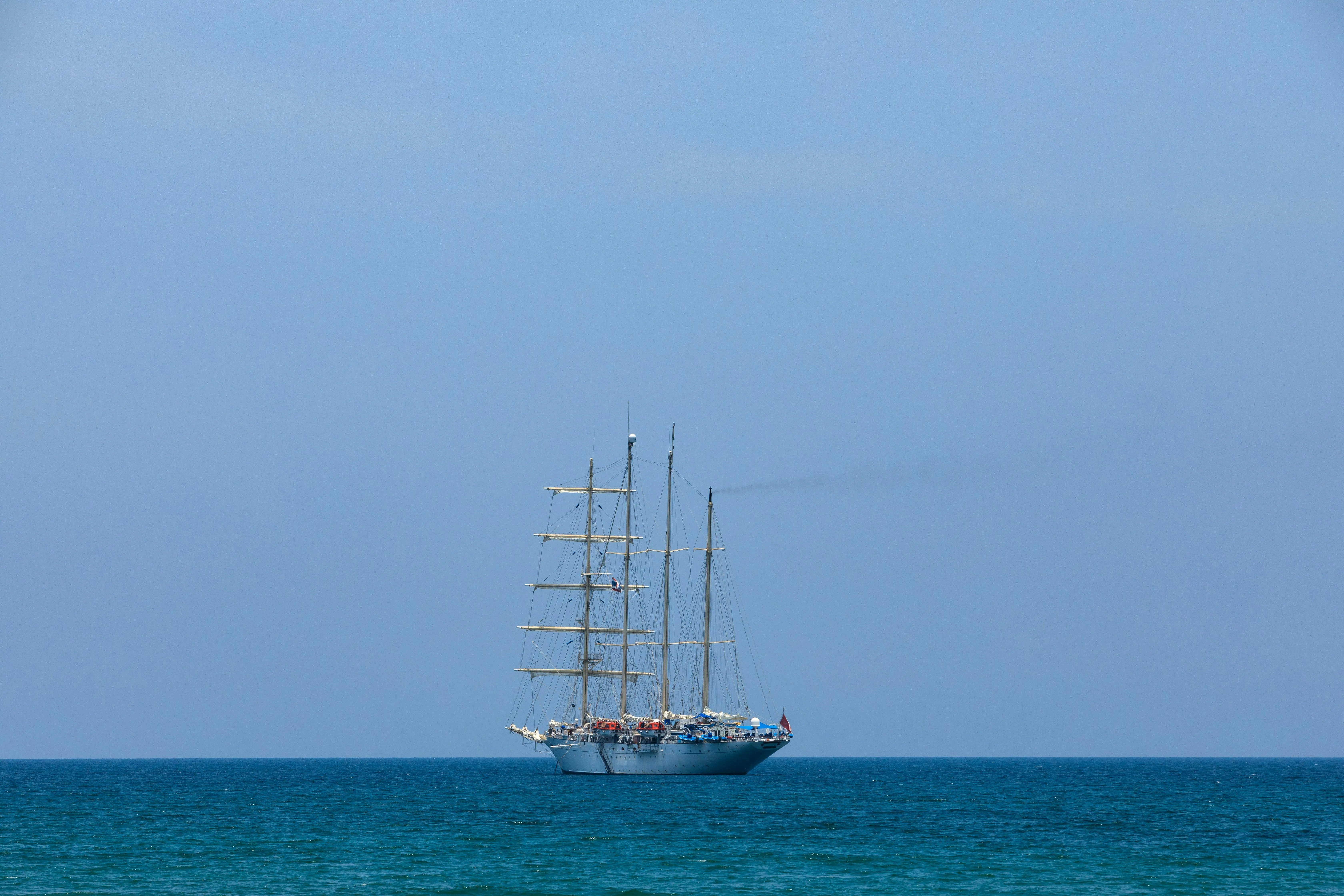Square sails set and drawing, the classic trade-wind rig that carries NEPTUN across the South Atlantic.