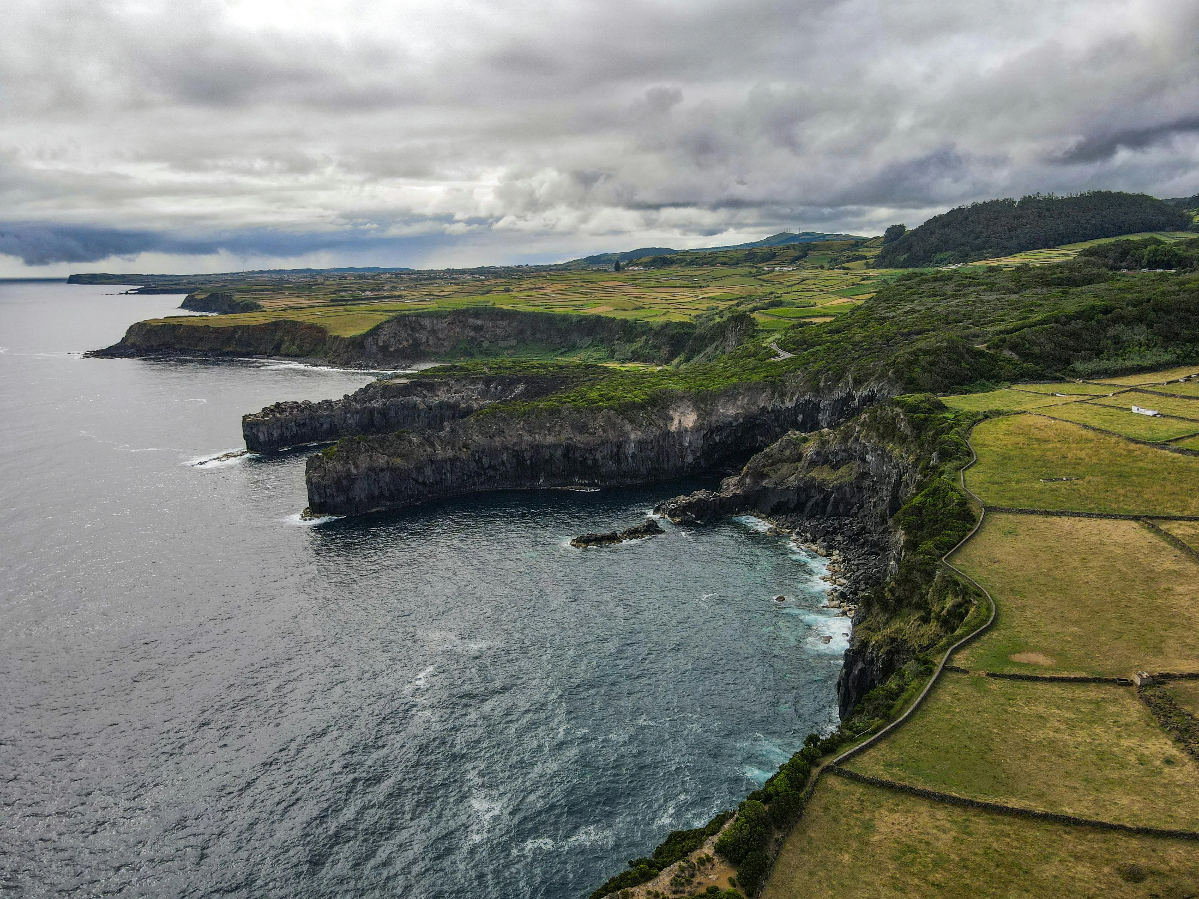 The volcanic cliffs of São Miguel, Azores, the last foreign shore of the voyage.