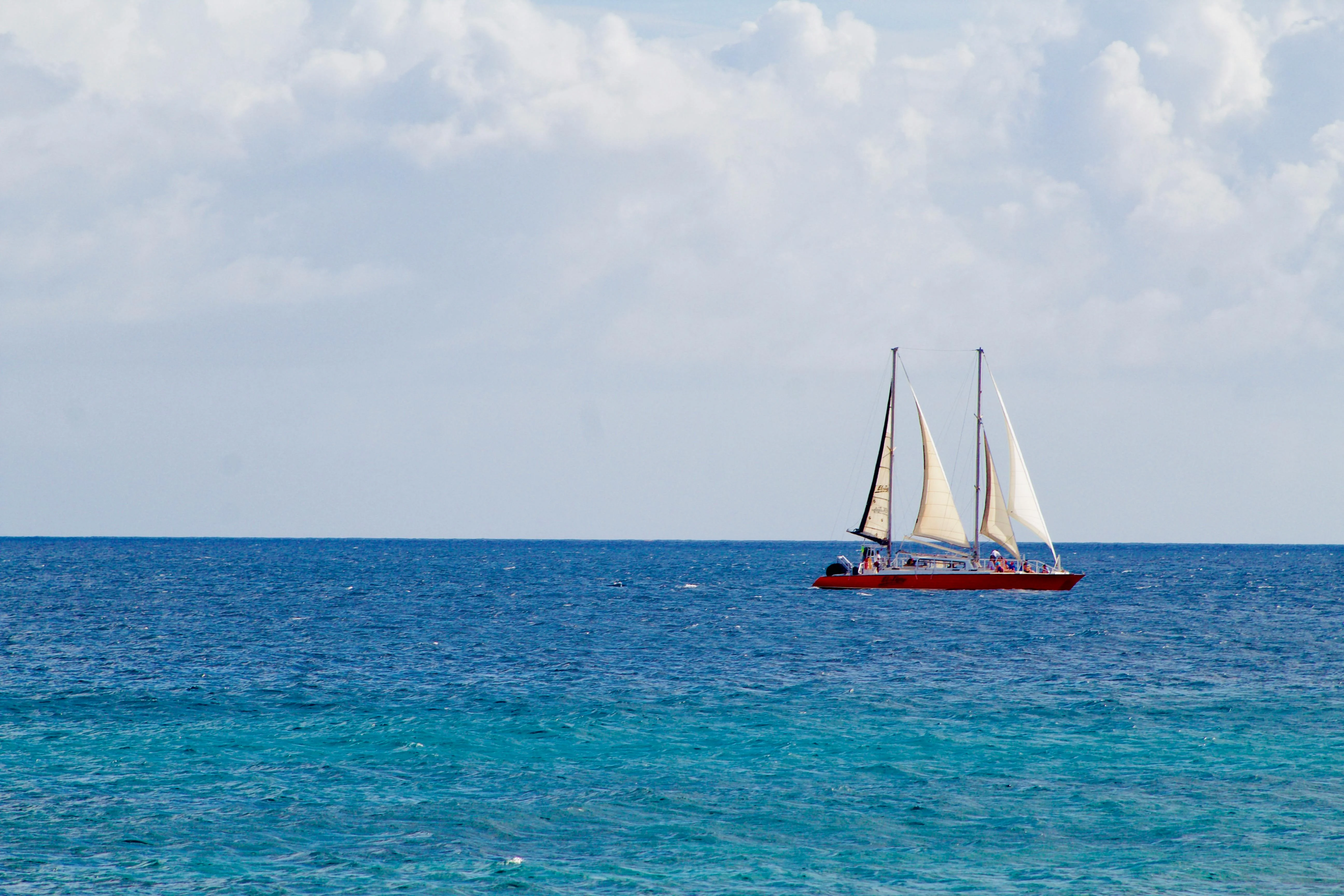 A sailboat reaches north under steady trades, the rhythm of every daysail on Leg 7.